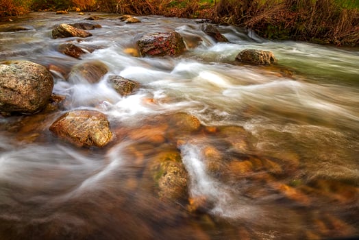 Beautiful autumn landscape of flowing water in mountain river photo