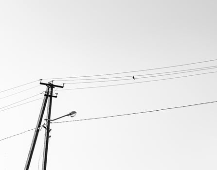 Power electric pole with line wire on light background close up photo