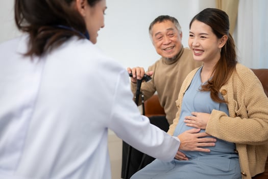 Father and daughter pregnant woman visit gynecologist doctor at medical clinic for pregnancy consultant. Doctor examine pregnant belly for baby and mother healthcare check up. photo