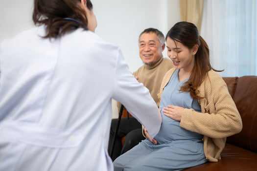 Father and daughter pregnant woman visit gynecologist doctor at medical clinic for pregnancy consultant. Doctor examine pregnant belly for baby and mother healthcare check up. photo