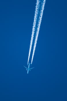 Plane and its condensation trail, cloud forming at the back of a plane, perfectly blue sky photo