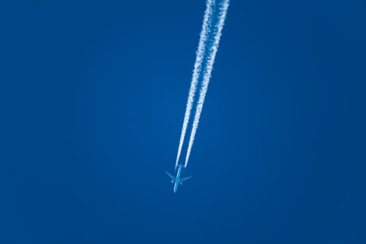 Plane and its condensation trail, cloud forming at the back of a plane, perfectly blue sky photo