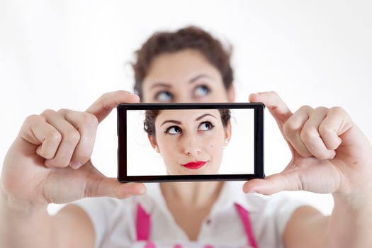 pretty woman taking a selfie using her smartphone photo
