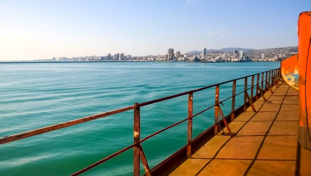 View of the sea and city beach from the port quay. Industrial port with tower cranes and cargo infrastructure photo