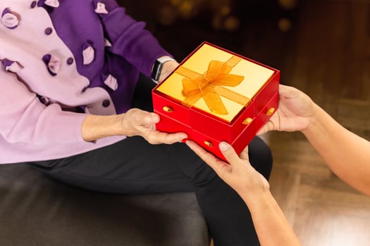 Daughter giving gift box to mother at home. photo