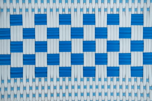 Texture of white and blue synthetic fabric. Perpendicularly woven white and blue plastic threads. photo