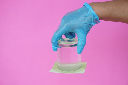 Closeup hand hold and turn a glass of water over down. covered the glass with paper. Concept,  science experiment about air and liquid pressure. Easy science subject activity, education. photo
