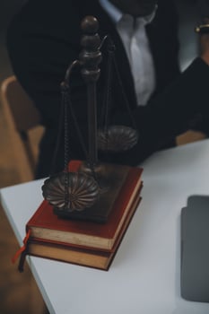 Business and lawyers discussing contract papers with brass scale on desk in office. Law, legal services, advice, justice and law concept picture with film grain effect photo