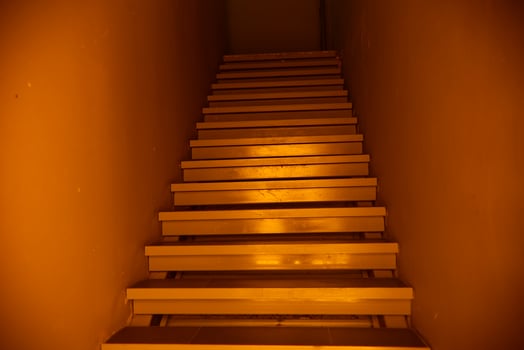dark orange golden light mysterious horror stairs inside the building photo