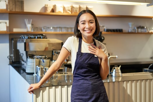 Portrait of smiling asian entrepreneur, independent coffee shop owner, wearing apron, working in cafe, wearing apron photo