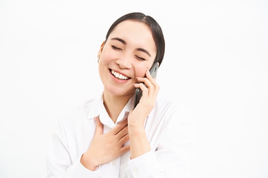 Portrait of asian corporate woman, businesswoman talks on mobile phone, has conversation over cellphone, speaking on telephone, white background photo