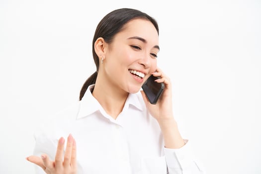 Portrait of asian corporate woman, businesswoman talks on mobile phone, has conversation over cellphone, speaking on telephone, white background photo