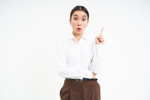Enthusiastic asian woman, entrepreneur points up, eureka gesture, has an idea, came up with solution, white background photo
