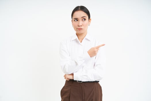 Image of female employee, office worker points finger at banner, shows promo advertisement on isolated white background photo