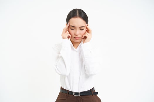 Tired corporate woman, office manager holds hands on head, has headache or migraine, stressed at work, whtie background photo