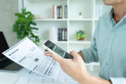 business man use phone to scan barcode or QR codes to pay credit card bill after receiving document invoice online. payment, receive, paying electricity, digital payments without money, technology photo
