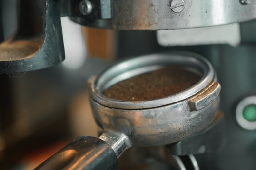Coffee beans in a portafilter by the coffee grinder photo