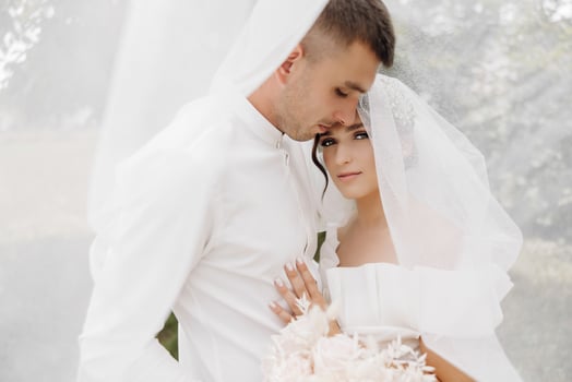 Beautiful wedding couple. the groom kisses the bride on the forehead. Happy wedding photography of bride and groom at wedding ceremony. photo