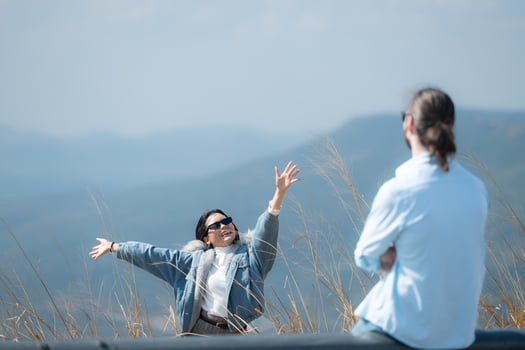 Young couple relaxing on the top of a hill in the mountains photo