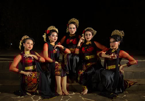 a group of dancers attract attention in striking red costumes and sit together photo