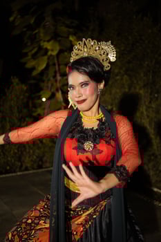 an Asian dancer dancing on her knees while wearing a black and luxurious costume in front of the audience photo