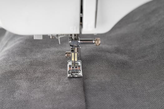 Modern sewing machine with gray fabric photo