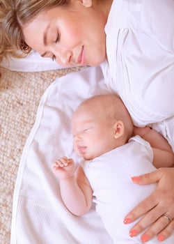 Newborn child sleeping with mom photo