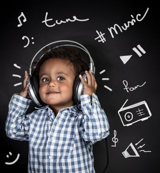 Happy little boy listening music photo
