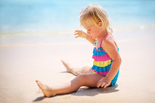 Baby girl playing on the beach photo
