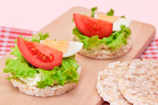 Rice Cake Sandwiches with Tomato, Lettuce and Egg on Wooden Cutting Board. Easy Breakfast. Diet Food. Quick and Healthy Sandwiches. Crispbread with Tasty Filling. Healthy Dietary Snack photo