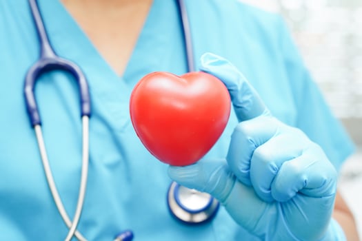 Asian woman doctor holding red heart for health in hospital. photo