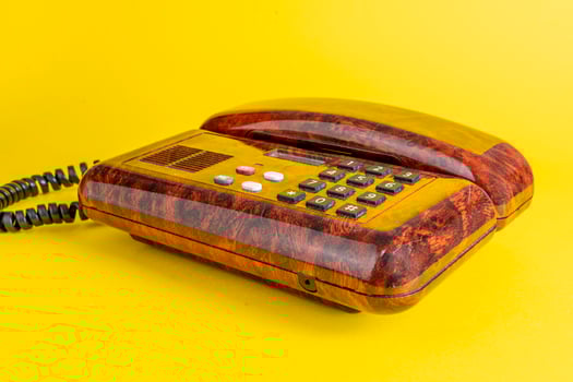 vintage telephone in imitation briar wood over a yellow background photo