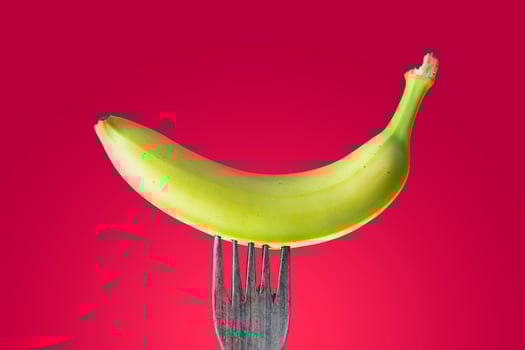 banana with peel skewered on a wooden fork photo