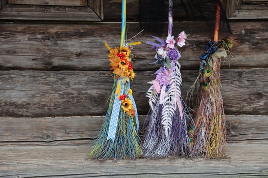 Three different brooms of witches stand at the old wooden hut house photo