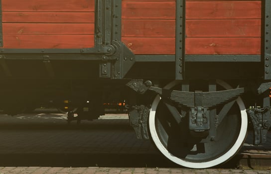 The side of the old brown wooden freight car with the wheel of the times of the Soviet Union photo