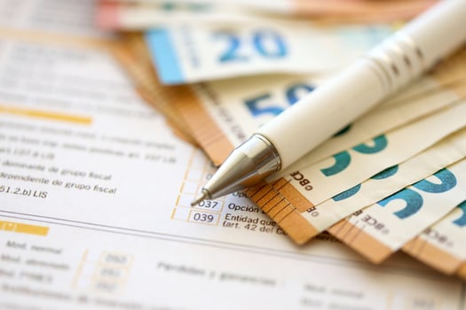Filling italian tax form process with pen and euro money bills close up. Tax paying period photo