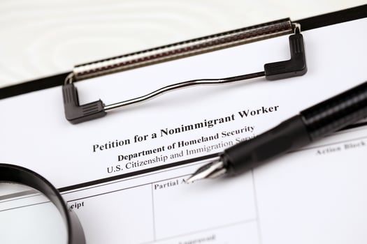 I-129 Petition for a nonimmigrant worker blank form on A4 tablet lies on office table with pen and magnifying glass photo