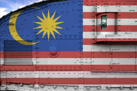 Malaysia flag depicted on side part of military armored tank closeup. Army forces conceptual background photo