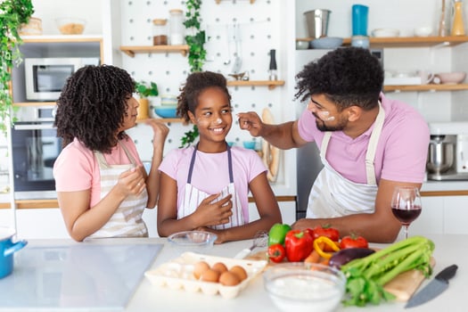 happy family with their daughter cooks in kitchen, kneads dough and bakes cookies photo