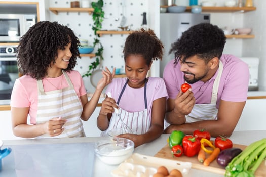 Kind african parents teaching their adorable daughter how to cook healthy food, free space photo