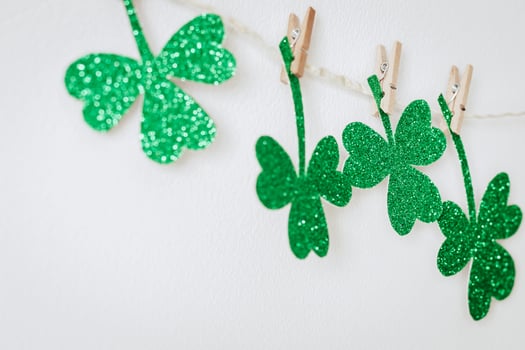 Happy St. Patricks day. Green glitter shamrocks decoration. Homemade garland of rope and clover leaves on clothespins photo