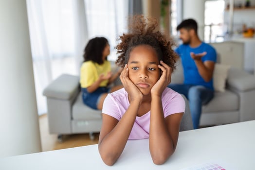 Frustrated little girl feeling depressed while angry parents fighting at home. Worried upset small daughter hurt by fathers and mothers break up or divorce. photo