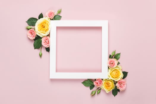 Creative layout made of beautiful roses on pink background. Minimal holiday concept with paper card frame photo