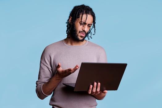 Confused arab man discussing bad idea in video conference on laptop. Young adult person explaining business strategy problem to customer in online meeting on portable computer photo