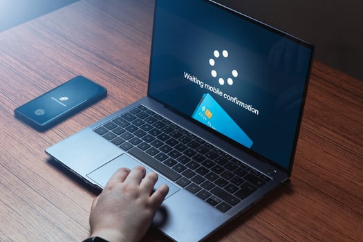 Woman use phone for online bank payment transfer on laptop. Business app. Shopping online. Digital purchase. Credit card. photo