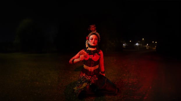 a group of female dancers with faces full of sadness sitting alone in the middle of a field photo