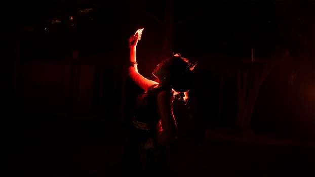 silhouette of a female dancer holding jewelry in the middle of the stillness of the night with red light photo