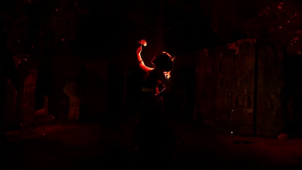 the silhouette of a female dancer holding jewelry that looks like a reflection reflecting in the dim light photo