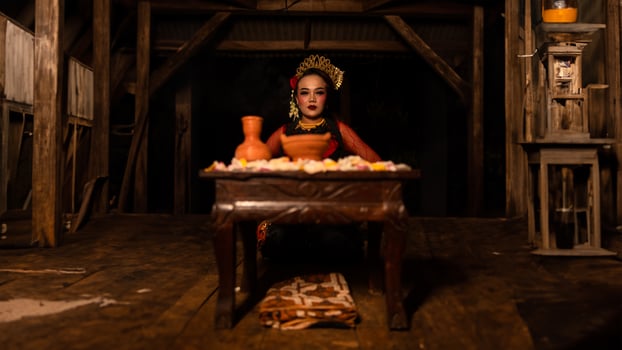 a female dancer sits gracefully and begins her ritual in front of beautiful offerings photo