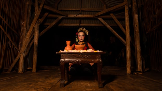 a female dancer sits gracefully and begins her ritual in front of beautiful offerings photo